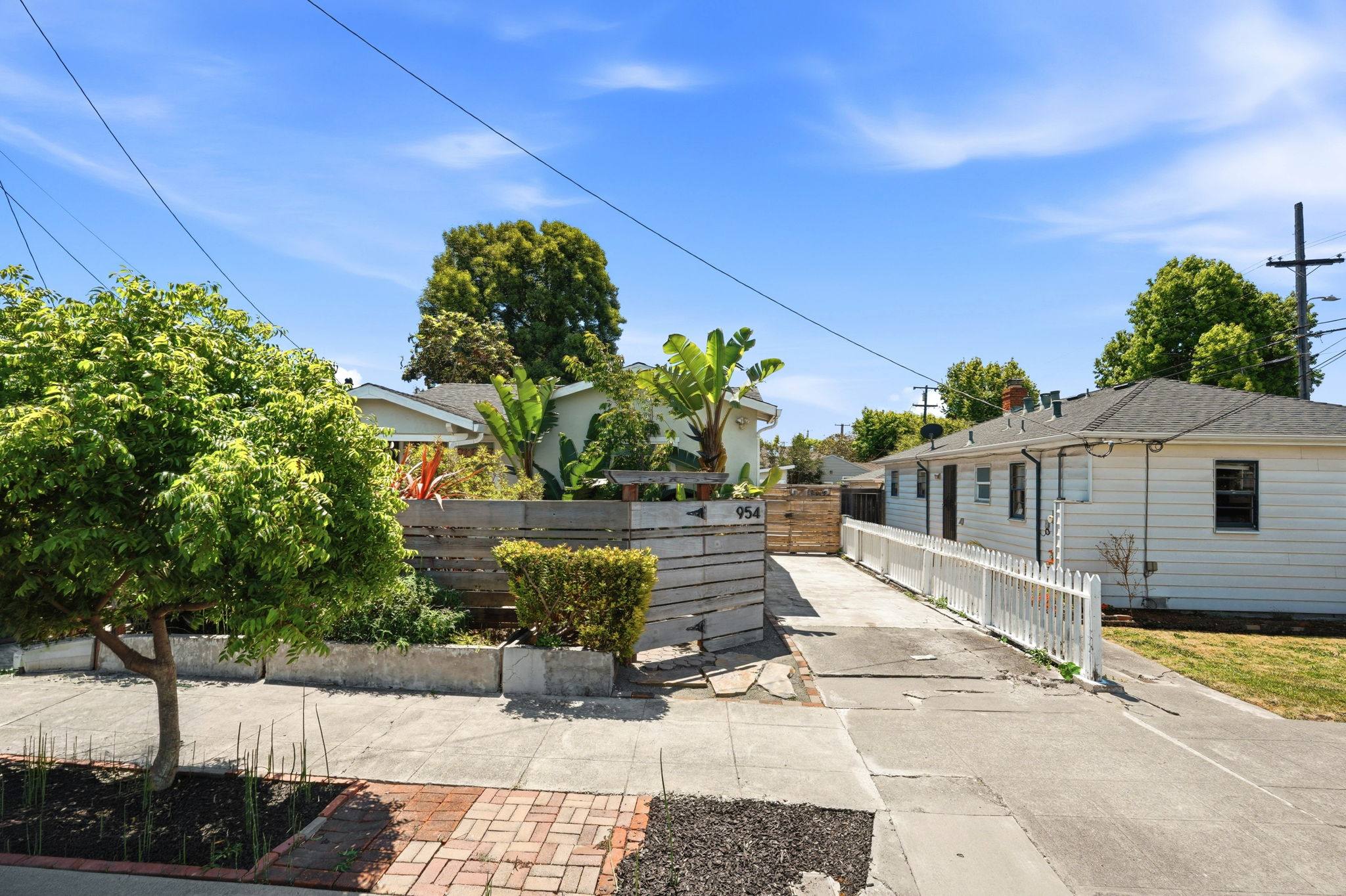 A Bay Vista–managed California bungalow with banana plants behind a low wooden fence.